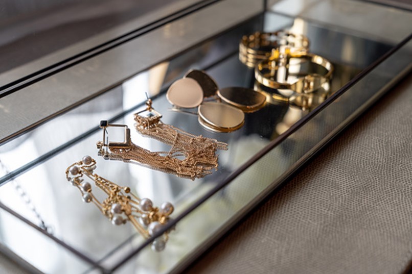 A group of jewelry on a glass shelf