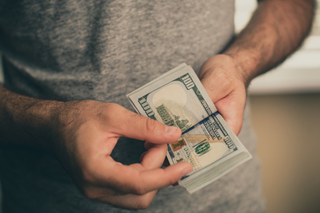 A person holding a stack of money